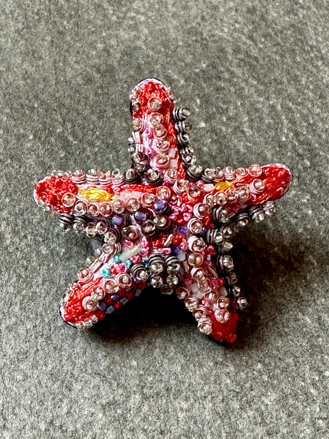 Decorative starfish with beads on a gray surface