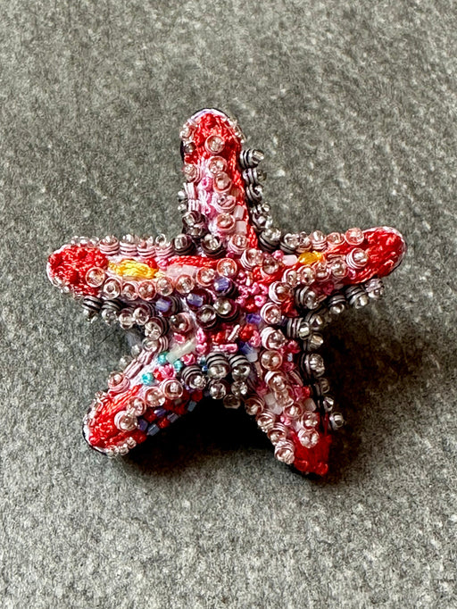 Decorative starfish with beads on a gray surface